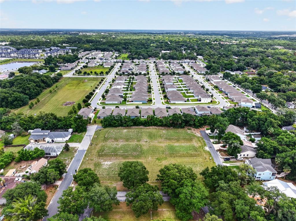 An aerial view shows a vacant rectangular lot surrounded by residential houses and green trees — FEARON AVE & E 19TH AVE AVENUE UNIT 1-6, MOUNT DORA, FL