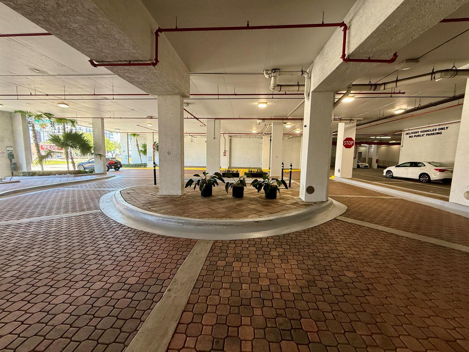 A covered parking area features brick pavers, concrete support columns, and potted plants — 140 S Dixie Highway # 813, Hollywood FL 33020, HOLLYWOOD, FL