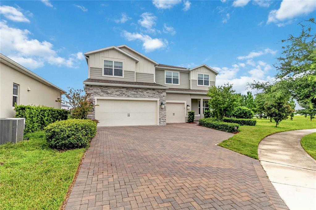 A two-story suburban house with a brick paver driveway and a three-car garage — 13485 PANAMA BEACH COURT, ORLANDO, FL