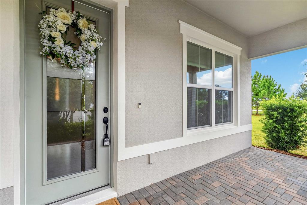 A front porch features a light gray door with a wreath and a large window — 13485 PANAMA BEACH COURT, ORLANDO, FL