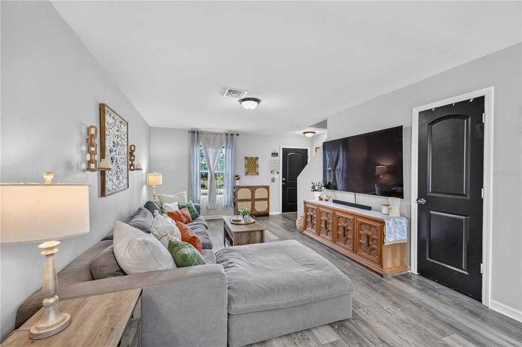 A dining room features a wooden table, chairs, a fish tank, and a glass door — 60 INDEPENDENCE STREET, PORT CHARLOTTE, FL