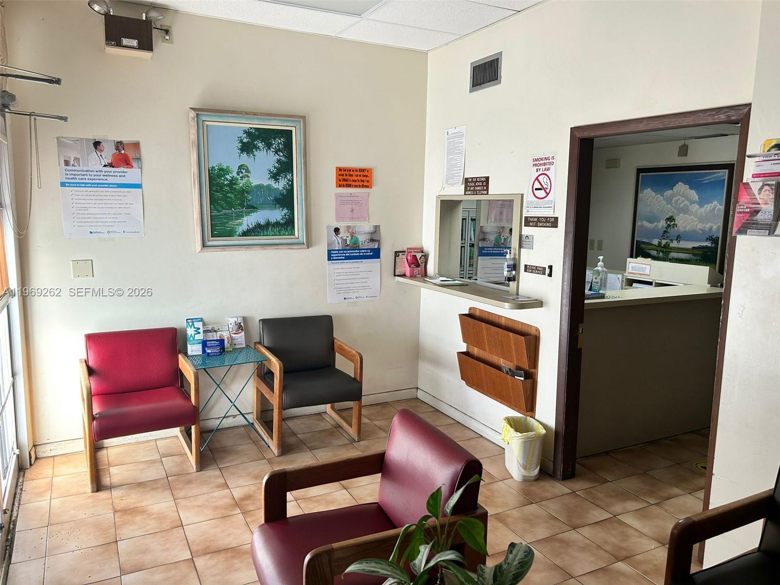 A waiting room with tile floors, several chairs, a reception window, and framed wall art — 8333 NE 2nd Ave, Miami FL 33138, MIAMI, FL
