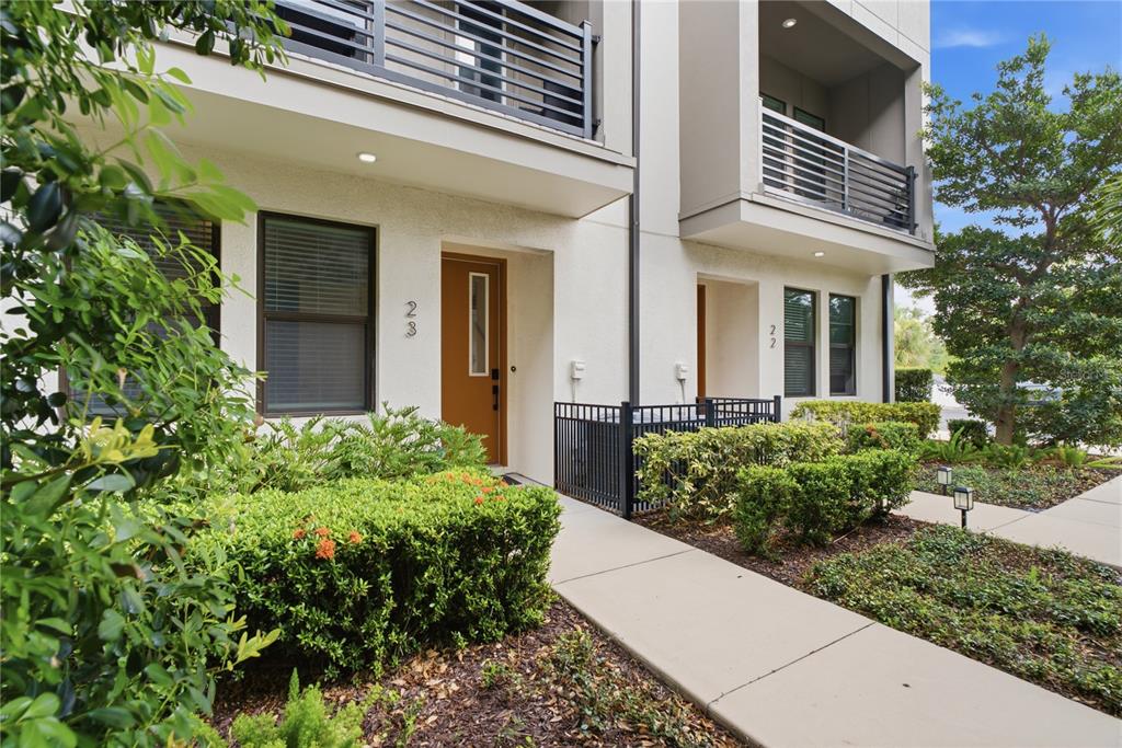 A view of the exterior of two adjacent townhomes with brown doors and small balconies — 2511 N GRADY AVENUE UNIT 23, TAMPA, FL