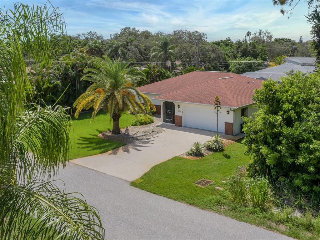 An aerial view of a single-story house with a red roof, garage, and palm tree — 1211 SOUTHLAND ROAD, VENICE, FL