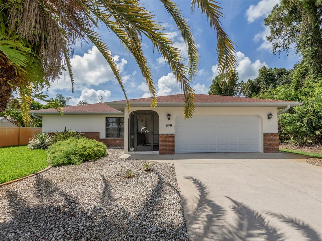 A single-story house with a white stucco facade, brick accents, and a two-car garage — 1211 SOUTHLAND ROAD, VENICE, FL