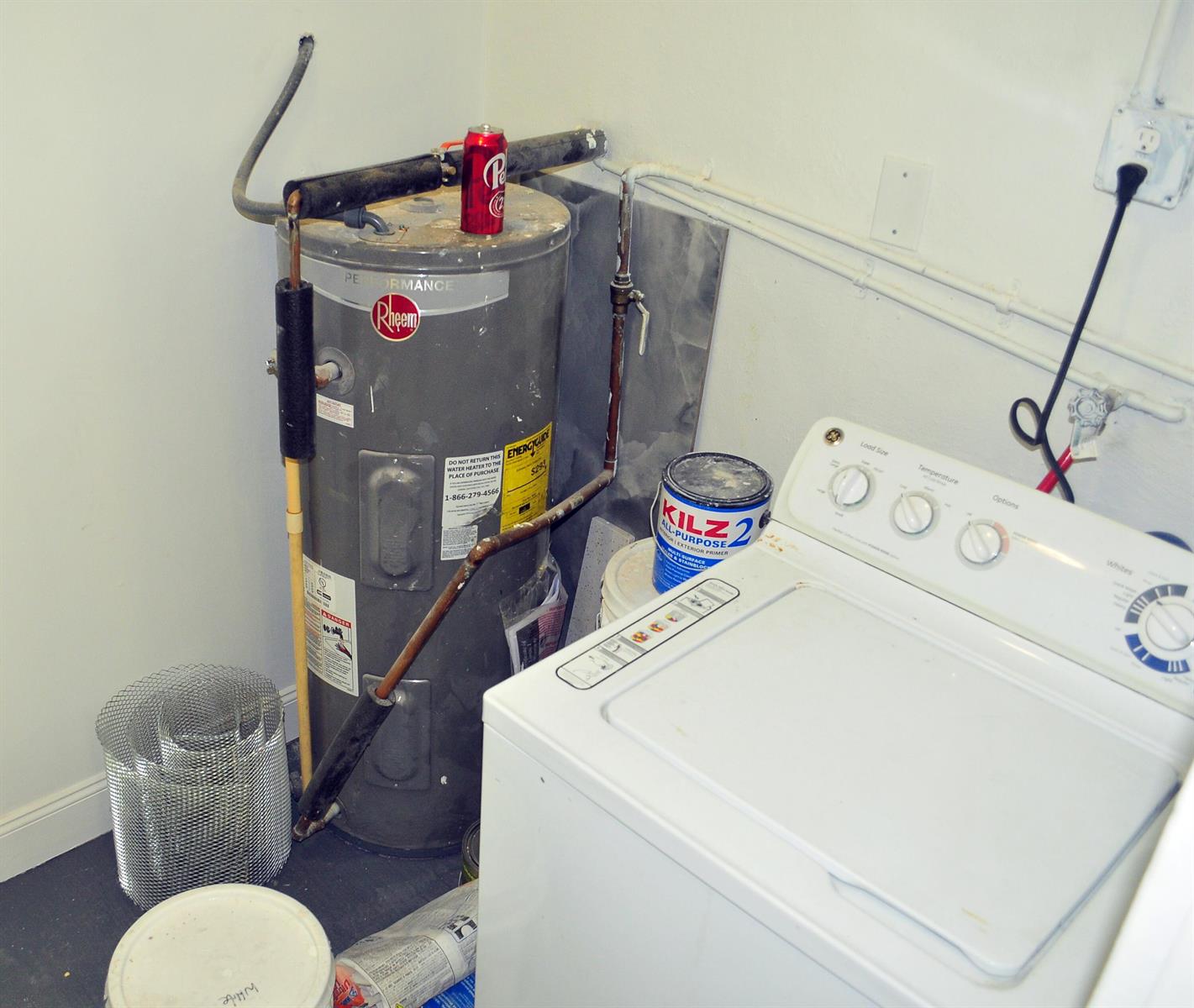 A utility room features a Rheem water heater, a white washing machine, and paint supplies — 936 45th Street, West Palm Beach FL 33407, WEST PALM BEACH, FL