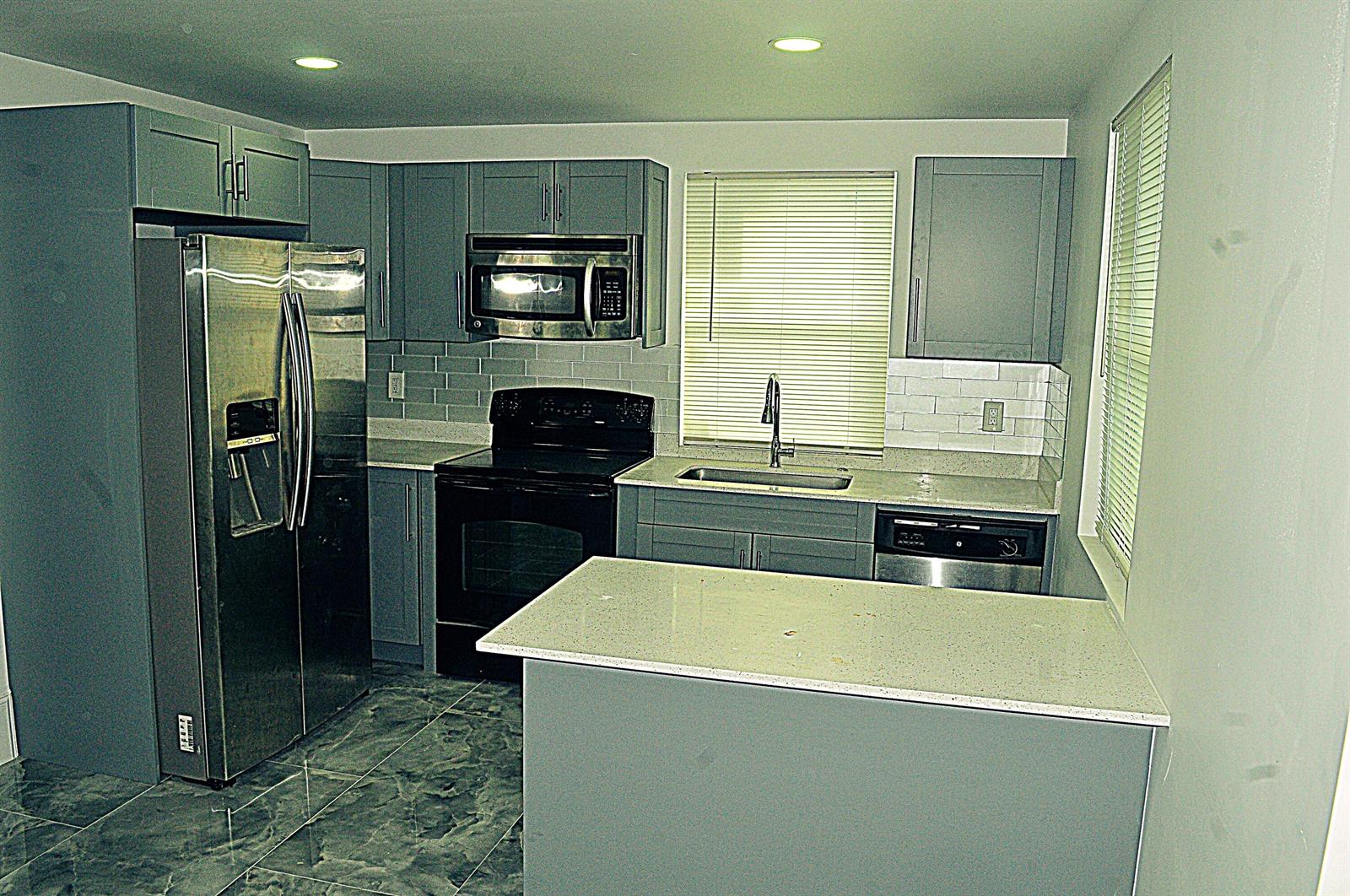 A kitchen with gray cabinets, stainless steel appliances, a white countertop, and gray tile flooring — 936 45th Street, West Palm Beach FL 33407, WEST PALM BEACH, FL
