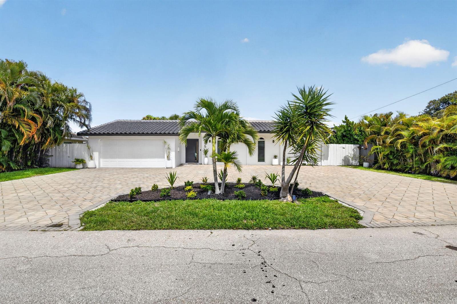 A single-story white house features a large paved driveway and a central landscaped garden bed — 876 NW 6th Avenue, Boca Raton FL 33432, BOCA RATON, FL