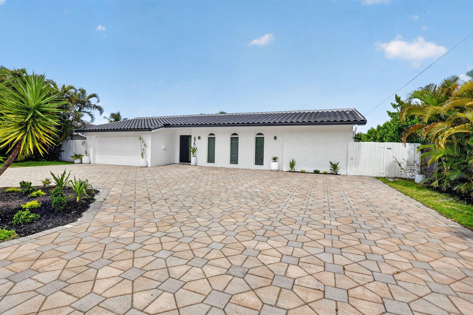 A white single-story house with a tiled roof and a large patterned paver driveway — 876 NW 6th Avenue, Boca Raton FL 33432, BOCA RATON, FL