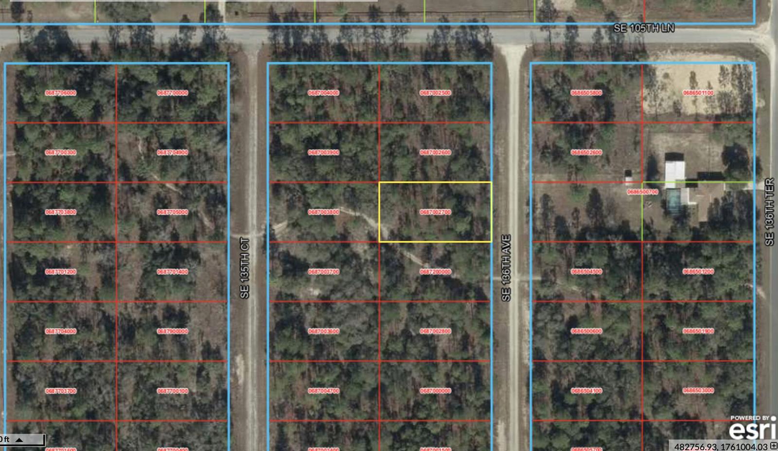 This is an aerial map showing a highlighted rectangular land parcel surrounded by wooded lots — 0 SE 136 Avenue, FL 32668, FL
