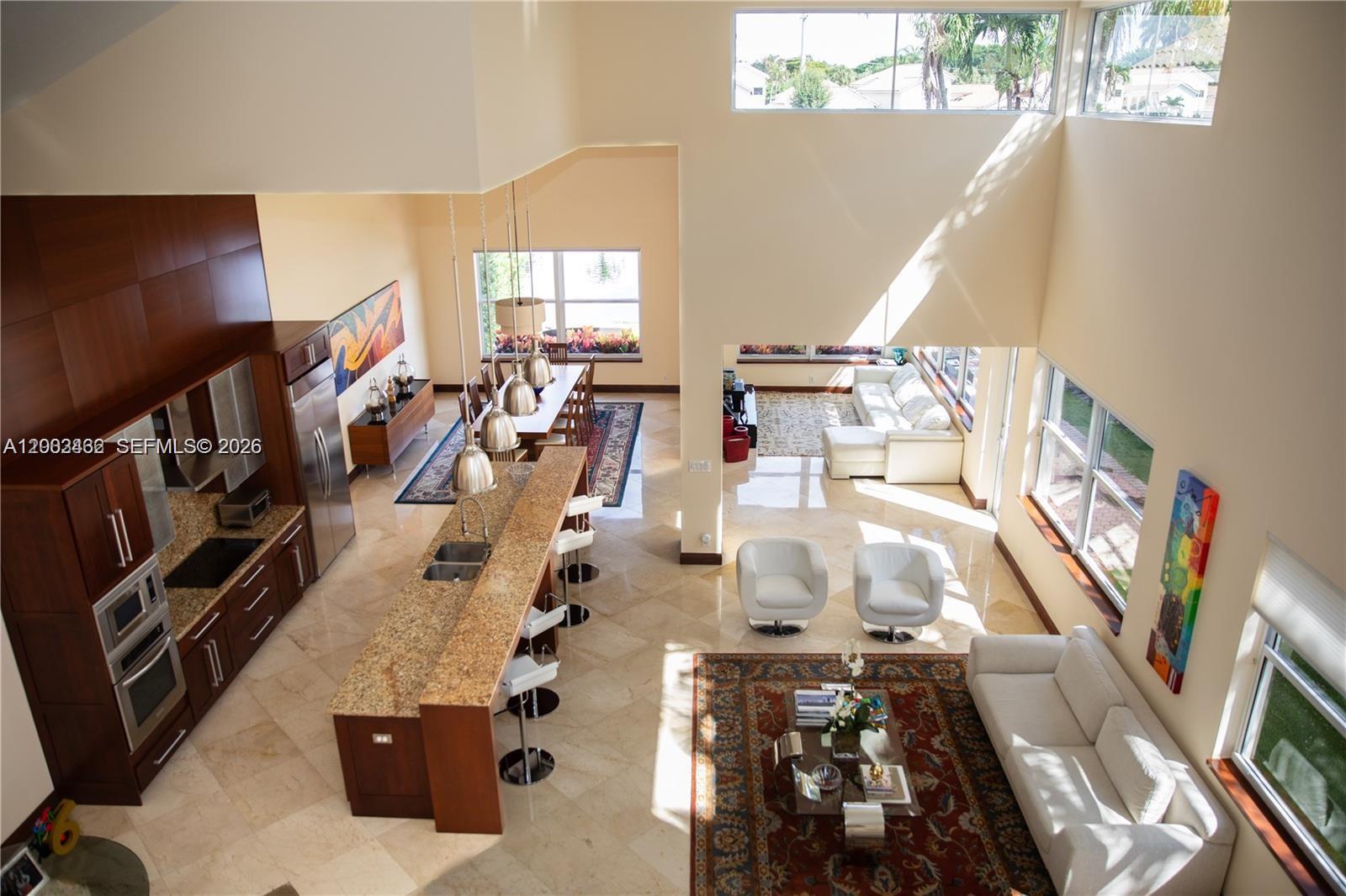An open-concept living area features a kitchen with granite counters, dining space, and high ceilings — 2485 NW 66th Dr # 0, Boca Raton FL 33496, BOCA RATON, FL