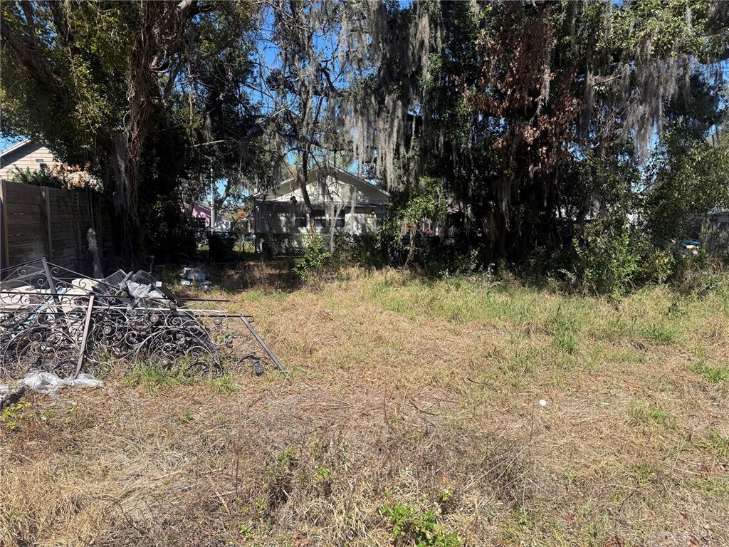 A vacant, overgrown lot features a pile of decorative metal fencing in the foreground — 669 W COMSTOCK AVENUE, WINTER PARK, FL