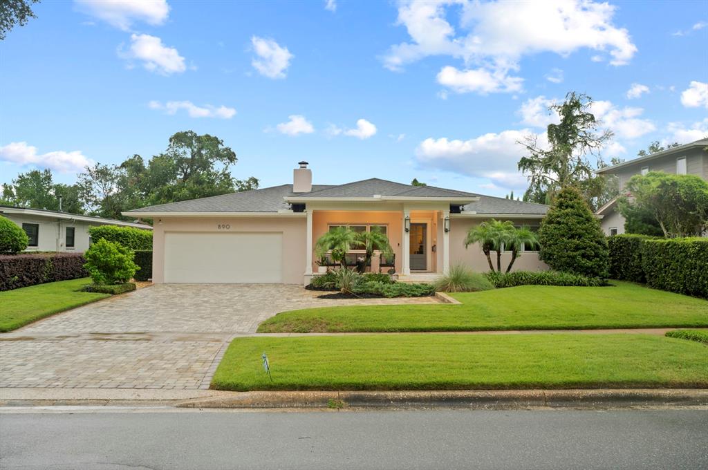 A single-story house with a paved driveway, a two-car garage, and a covered front porch — 890 N PHELPS AVENUE, WINTER PARK, FL