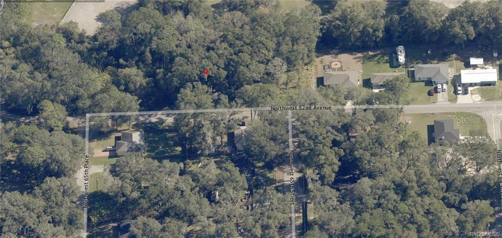 This is an aerial view of a wooded residential lot marked with a red pin — 00 NW 52ND AVENUE Lot 5, OCALA, FL