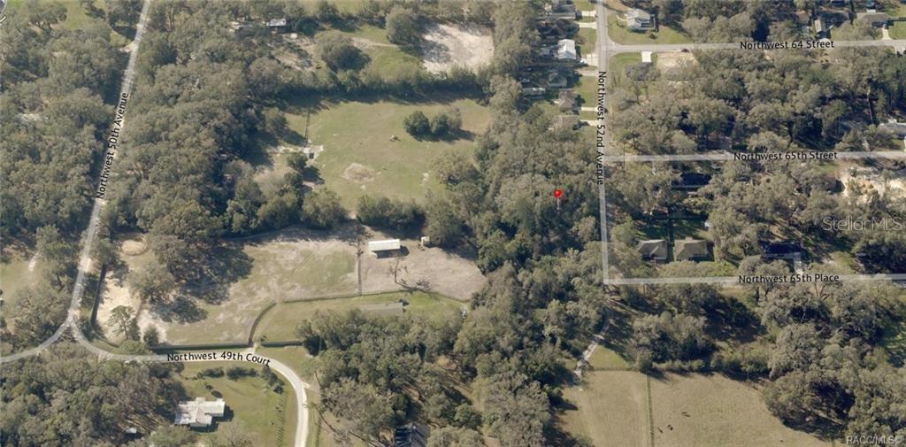 This aerial map view shows a wooded lot with a small structure and surrounding roads — 00 NW 52ND AVENUE Lot 5, OCALA, FL