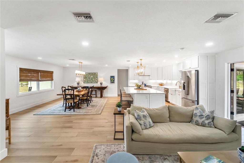 An open-concept living area features a kitchen with a large island, dining space, and hardwood floors — 1515 21ST STREET W, PALMETTO, FL