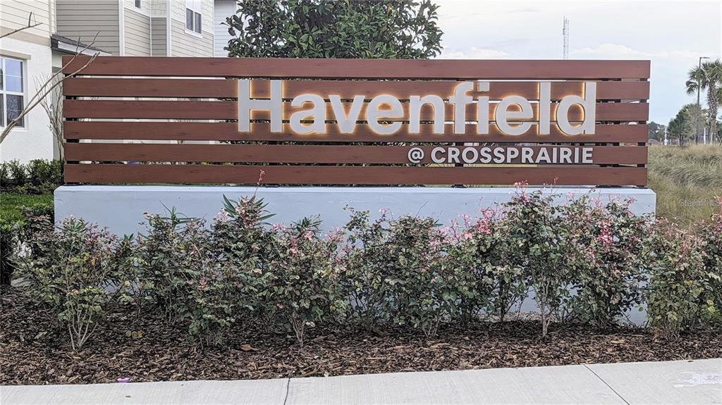 A wooden sign for Havenfield at Crossprairie stands in front of a residential building — 4961 RAIN SHADOW DRIVE, ST CLOUD, FL