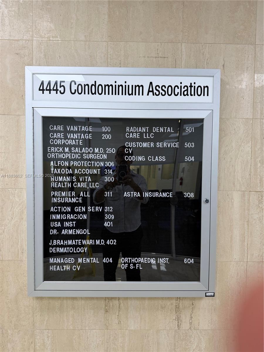 A directory board for the 4445 Condominium Association lists various businesses and their suite numbers — 4445 W 16th Ave # 605, Hialeah FL 33012, HIALEAH, FL