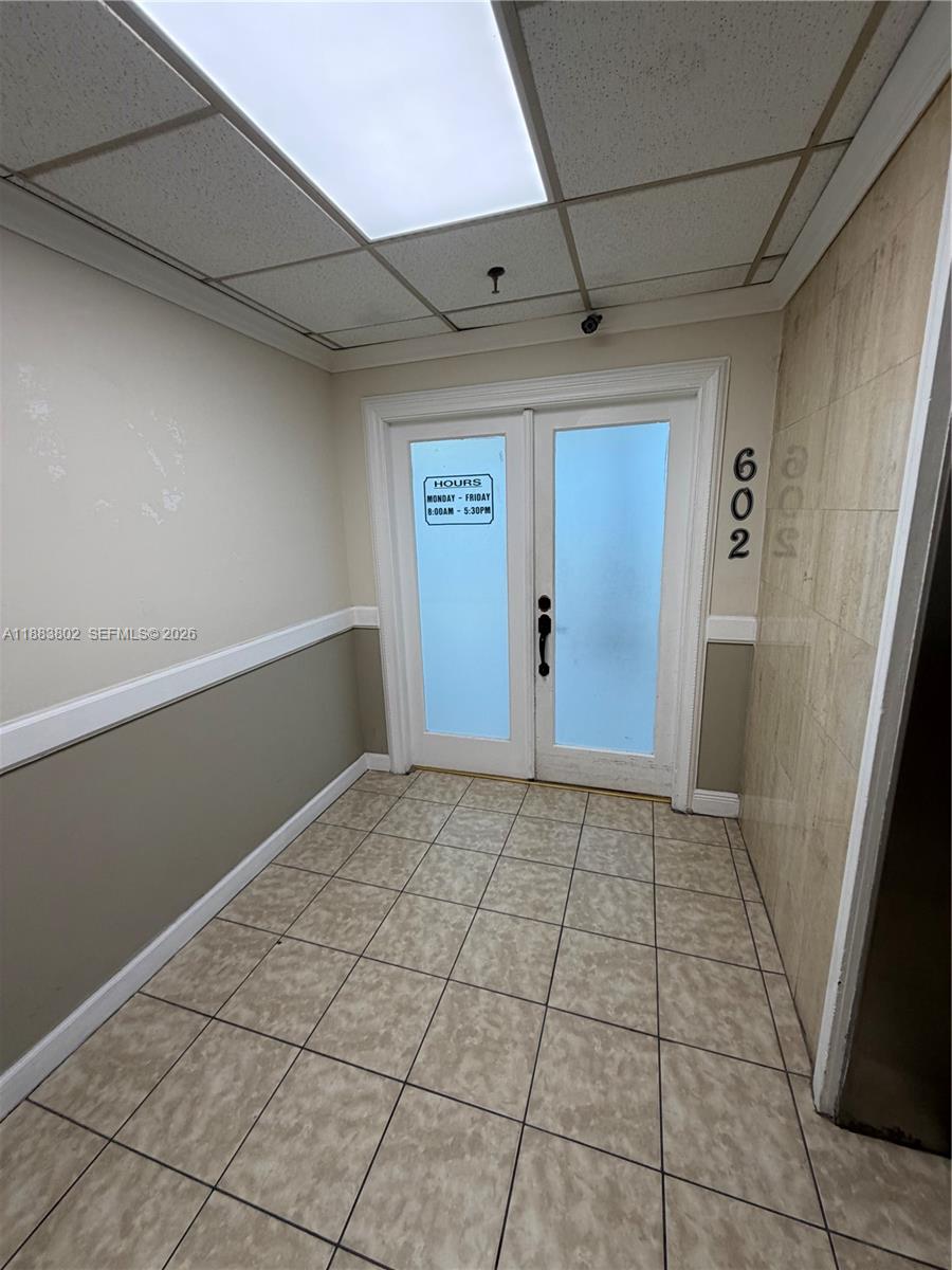 A small office entryway features tiled floors, a drop ceiling, and double glass doors — 4445 W 16th Ave # 605, Hialeah FL 33012, HIALEAH, FL
