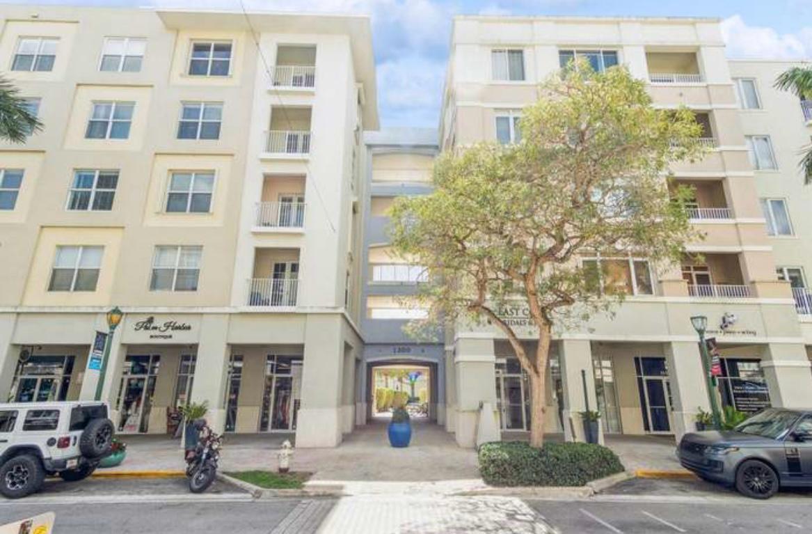 A multi-story apartment building with ground-floor retail spaces and a central pedestrian walkway — 1200 Town Center Drive # 305, Jupiter FL 33458, JUPITER, FL