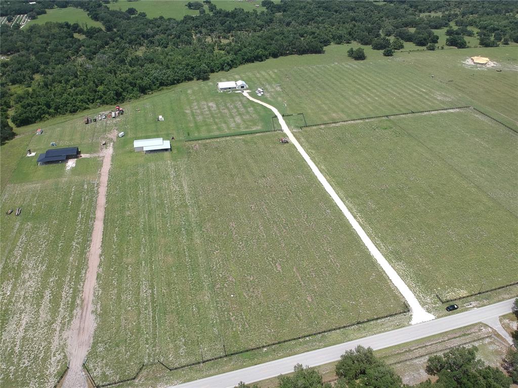 An aerial view shows a large rural property with multiple outbuildings, pastures, and gravel driveways — 5081 SE CREEKSIDE LANE, ARCADIA, FL