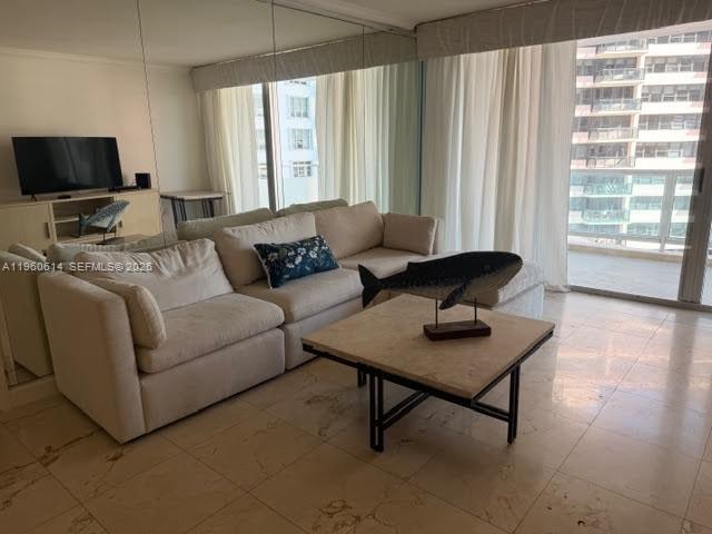 A living room features a beige sectional sofa, a stone coffee table, and floor-to-ceiling windows — 5161 Collins Ave # 703, Miami Beach FL 33140, MIAMI BEACH, FL