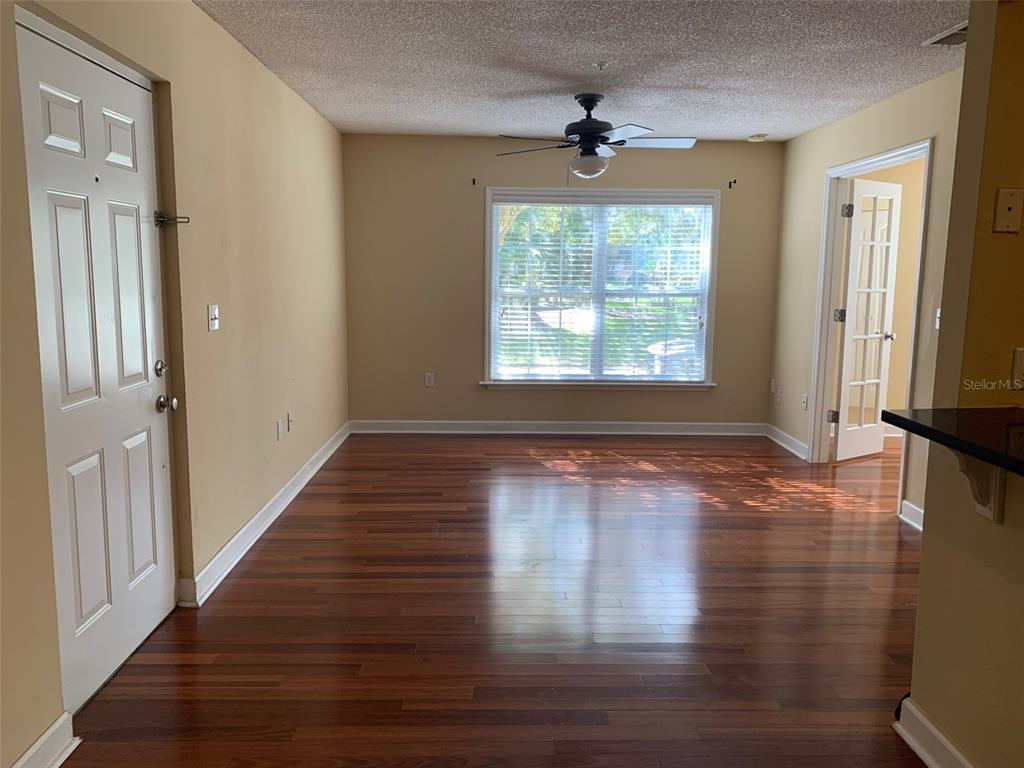 An empty room with hardwood floors, a ceiling fan, and a window overlooking greenery — 2007 DIXIE BELLE DRIVE UNIT 2007D, ORLANDO, FL