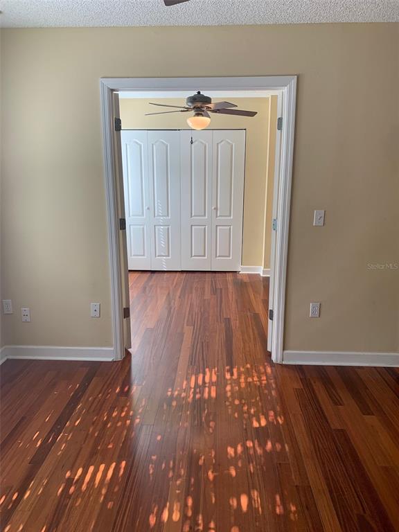 A room with hardwood floors leads through a doorway to another room with white closets — 2007 DIXIE BELLE DRIVE UNIT 2007D, ORLANDO, FL