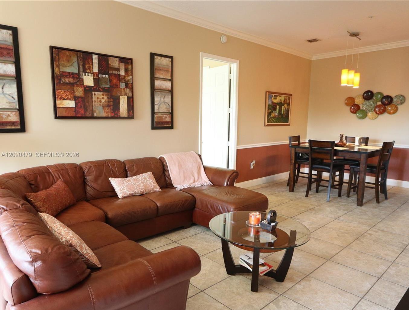 A living room with a brown leather sectional sofa and an adjacent dining area — 4602 SW 160th Ave # 533, Miramar FL 33027, MIRAMAR, FL