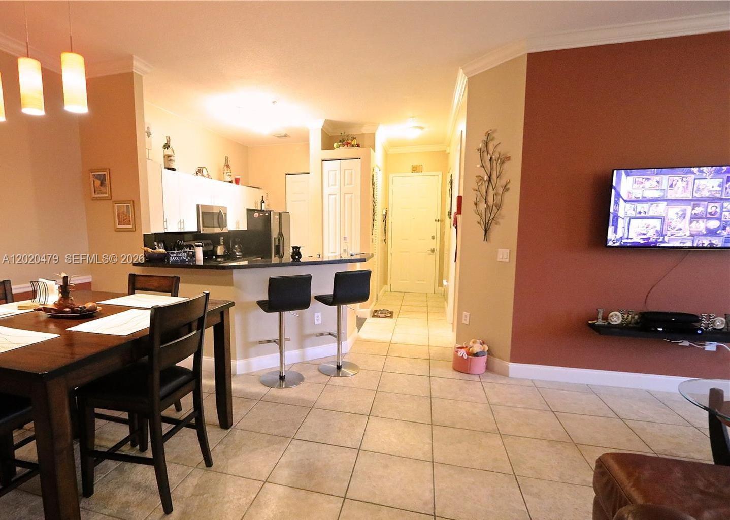 An open-concept kitchen and dining area features tile flooring, a breakfast bar, and pendant lighting — 4602 SW 160th Ave # 533, Miramar FL 33027, MIRAMAR, FL