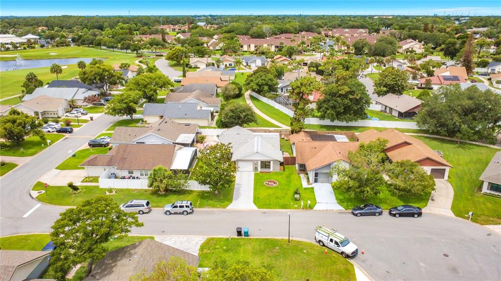 An aerial view shows a suburban neighborhood with single-family homes, paved streets, and green lawns — 2908 BRIDGEGATE COURT, ORLANDO, FL