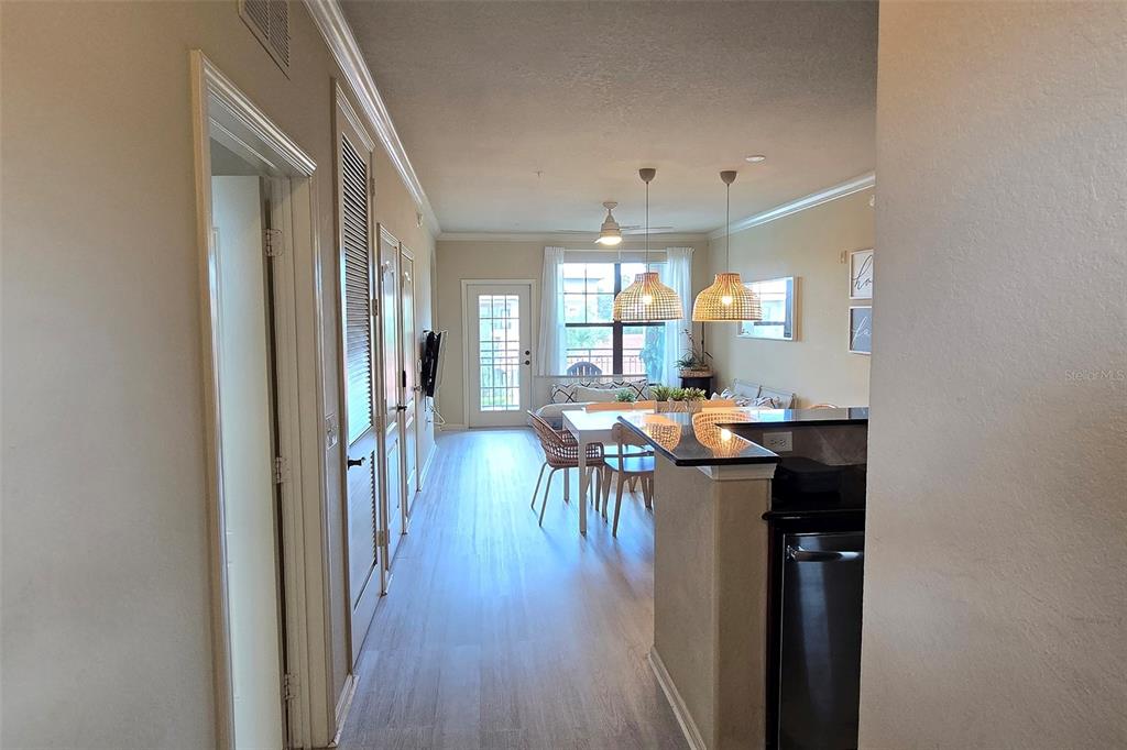 A view from a hallway looking into an open-concept dining and living area — 912 CHARO PARKWAY UNIT 233, DAVENPORT, FL