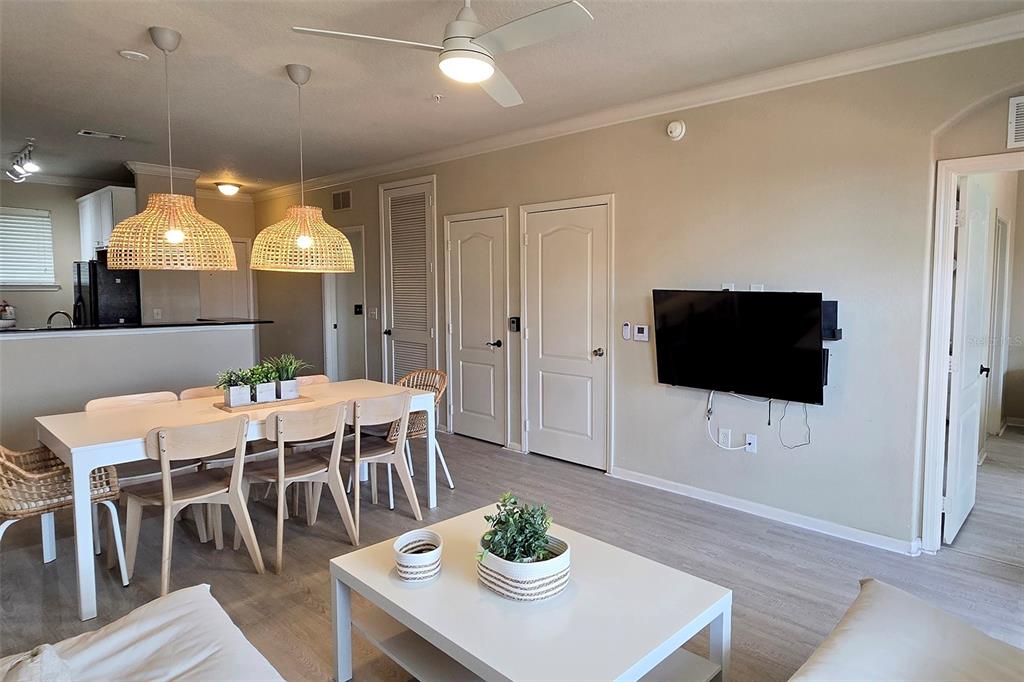 An open-concept living and dining area with light wood-look flooring and a ceiling fan — 912 CHARO PARKWAY UNIT 233, DAVENPORT, FL