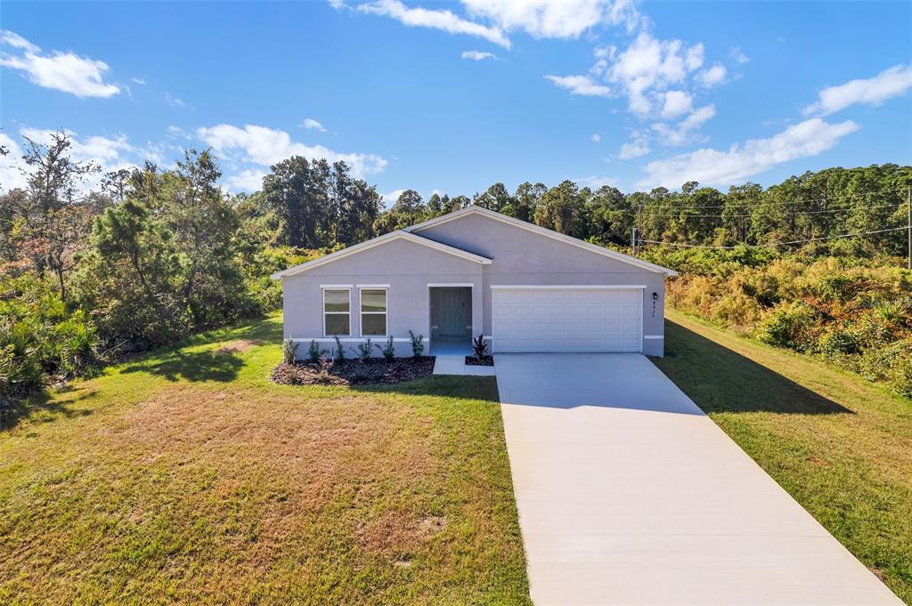 A single-story house with a gray exterior, a two-car garage, and a concrete driveway — 810 DARLINGTON AVENUE SW, PALM BAY, FL