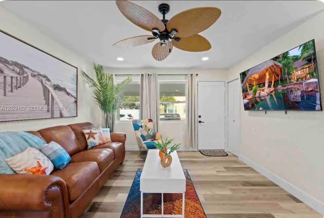 A living room features a brown leather sofa, a white coffee table, and a ceiling fan — 301 N Hollywood Ave, Daytona FL 32118, DAYTONA, FL