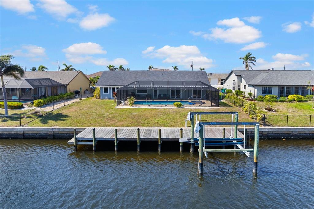 An aerial view of a waterfront house with a pool, screened lanai, and wooden dock — 4196 EASTLAKE COURT, PORT CHARLOTTE, FL