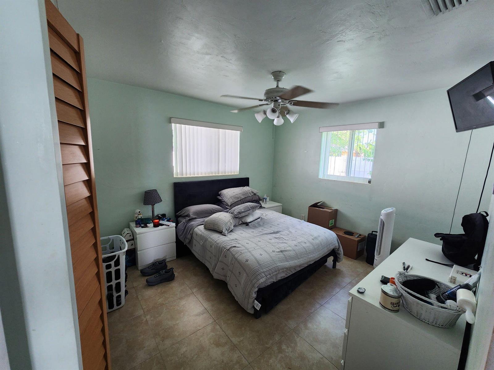 A backyard features artificial turf, a papaya tree, two fruit trees, and a white fence — 2016 Kenwood Road, West Palm Beach FL 33409, WEST PALM BEACH, FL