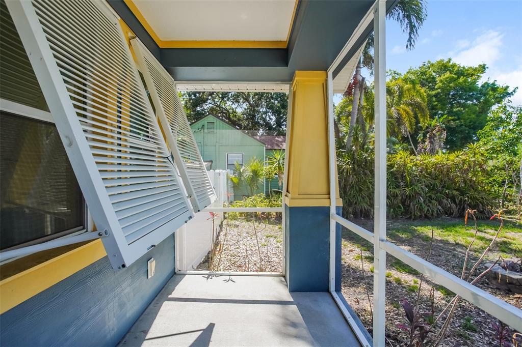 A screened-in porch with blue siding, yellow trim, and open louvered shutters — 1922 20TH AVENUE N, ST PETERSBURG, FL