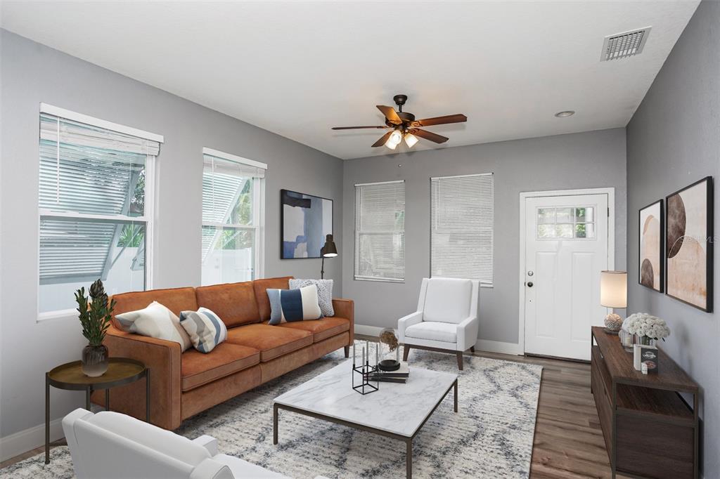 A living room features a brown leather sofa, white armchairs, a marble coffee table, and gray walls — 1922 20TH AVENUE N, ST PETERSBURG, FL