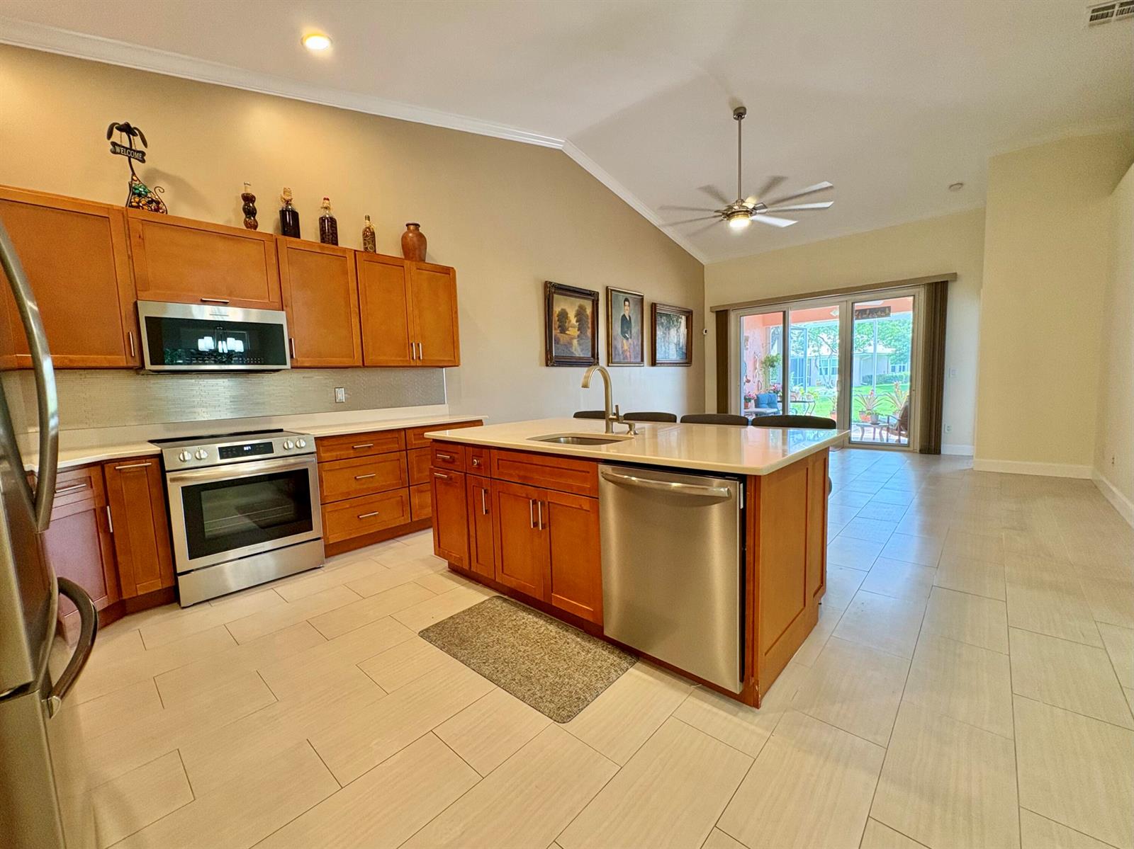 A kitchen with wood cabinets, stainless steel appliances, and a central island with a sink — 315 Coral Trace Lane, Delray Beach FL 33445, DELRAY BEACH, FL