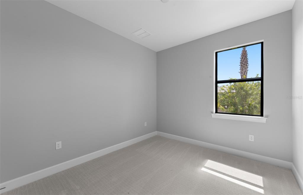 A single-story house with a paved driveway and a two-car garage under a blue sky — 4695 BLUE STAR COURT, NORTH PORT, FL