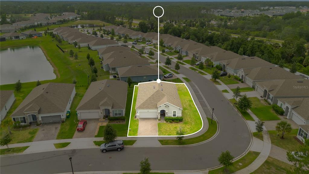 An aerial view shows a single-story suburban house with a paved driveway and corner lot — 1065 CHELAN FALLS DRIVE, DELAND, FL