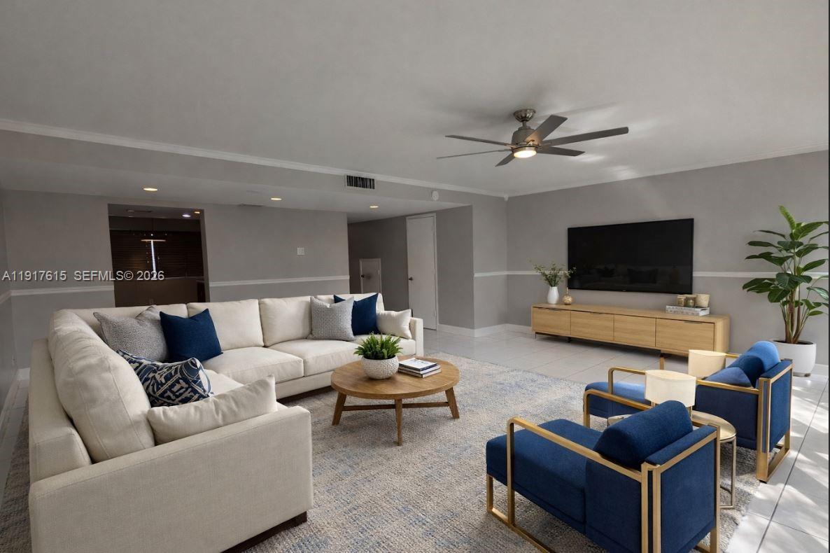 A living room features a large white sectional, two blue armchairs, and a wall-mounted television — 3530 NW 98th Ter # 5H, Sunrise FL 33351, SUNRISE, FL