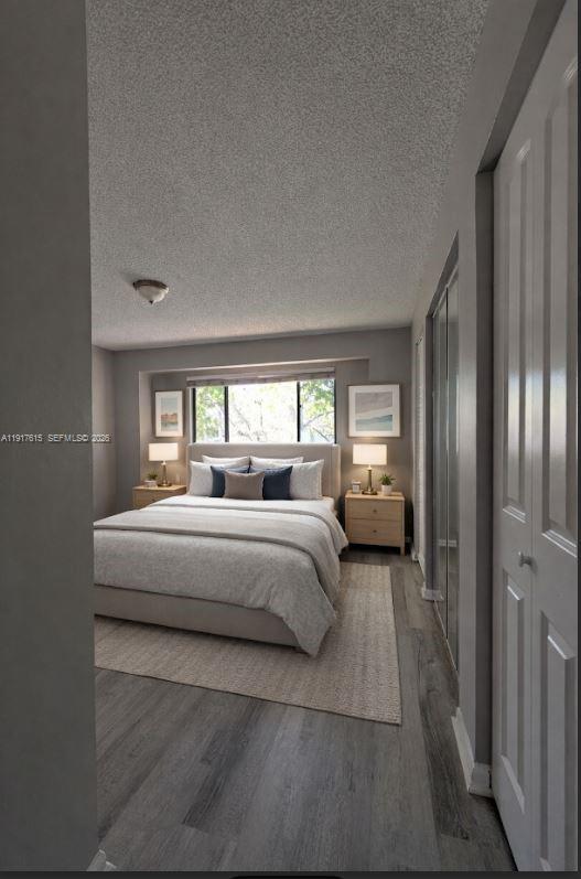 A bedroom features a bed with neutral bedding, two nightstands, and gray wood-look flooring — 3530 NW 98th Ter # 5H, Sunrise FL 33351, SUNRISE, FL