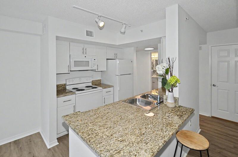 A kitchen features white cabinets, granite countertops, a breakfast bar, and stainless steel appliances — VERO BEACH, FL