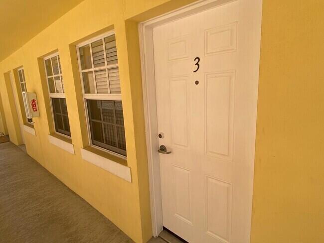 A yellow exterior wall features a white door labeled number three and two windows — 135 NW 5th Avenue # 3, Delray Beach FL 33444, DELRAY BEACH, FL