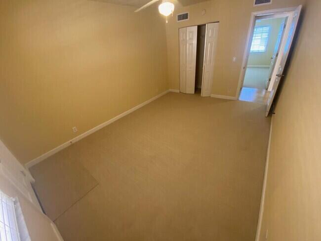 An empty bedroom features beige carpet, tan walls, a ceiling fan, and a closet — 135 NW 5th Avenue # 3, Delray Beach FL 33444, DELRAY BEACH, FL