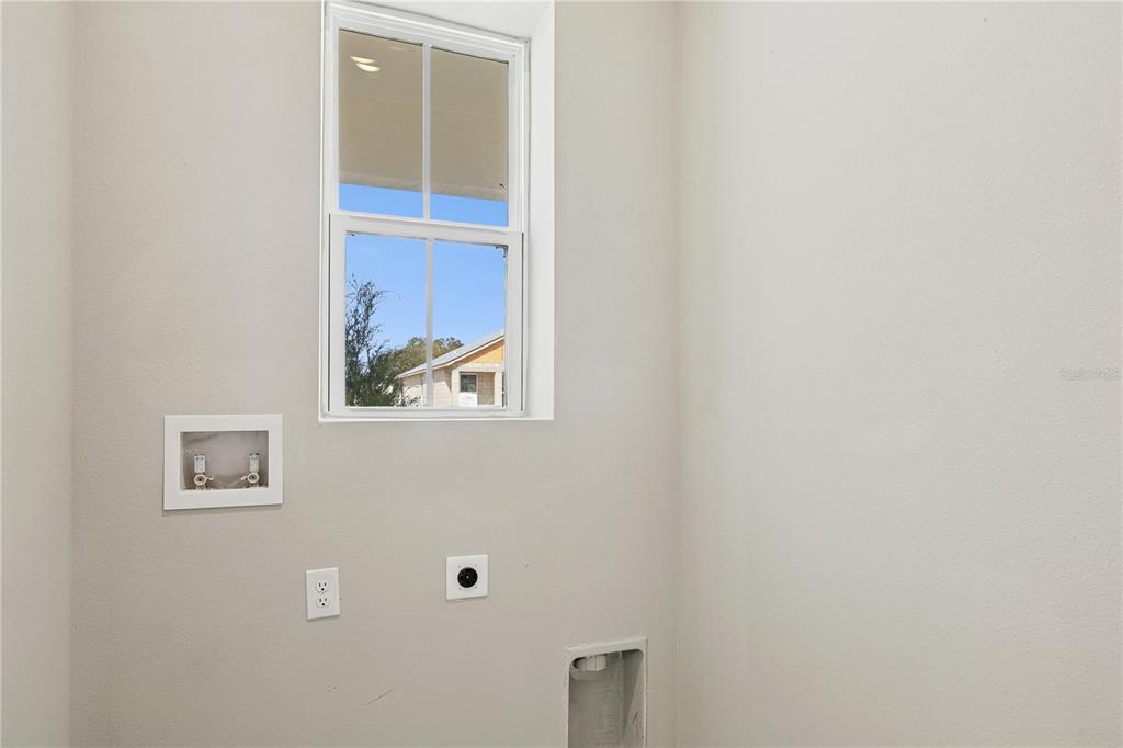 A laundry room with a window, utility hookups, and a standard electrical outlet — 4532 NW 37TH STREET RD, OCALA, FL