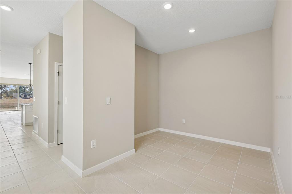 An empty room with beige walls, tile flooring, and recessed lighting — 4532 NW 37TH STREET RD, OCALA, FL