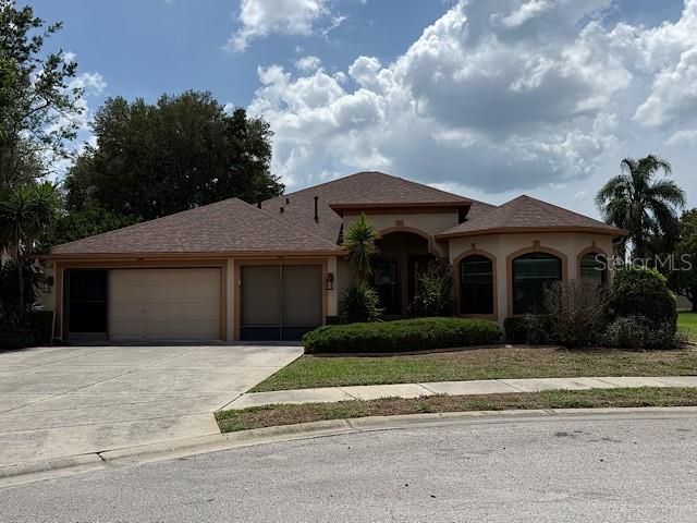 A single-story suburban house with a two-car garage and a brown shingled roof — 13743 BRYNDLEWOOD COURT, HUDSON, FL
